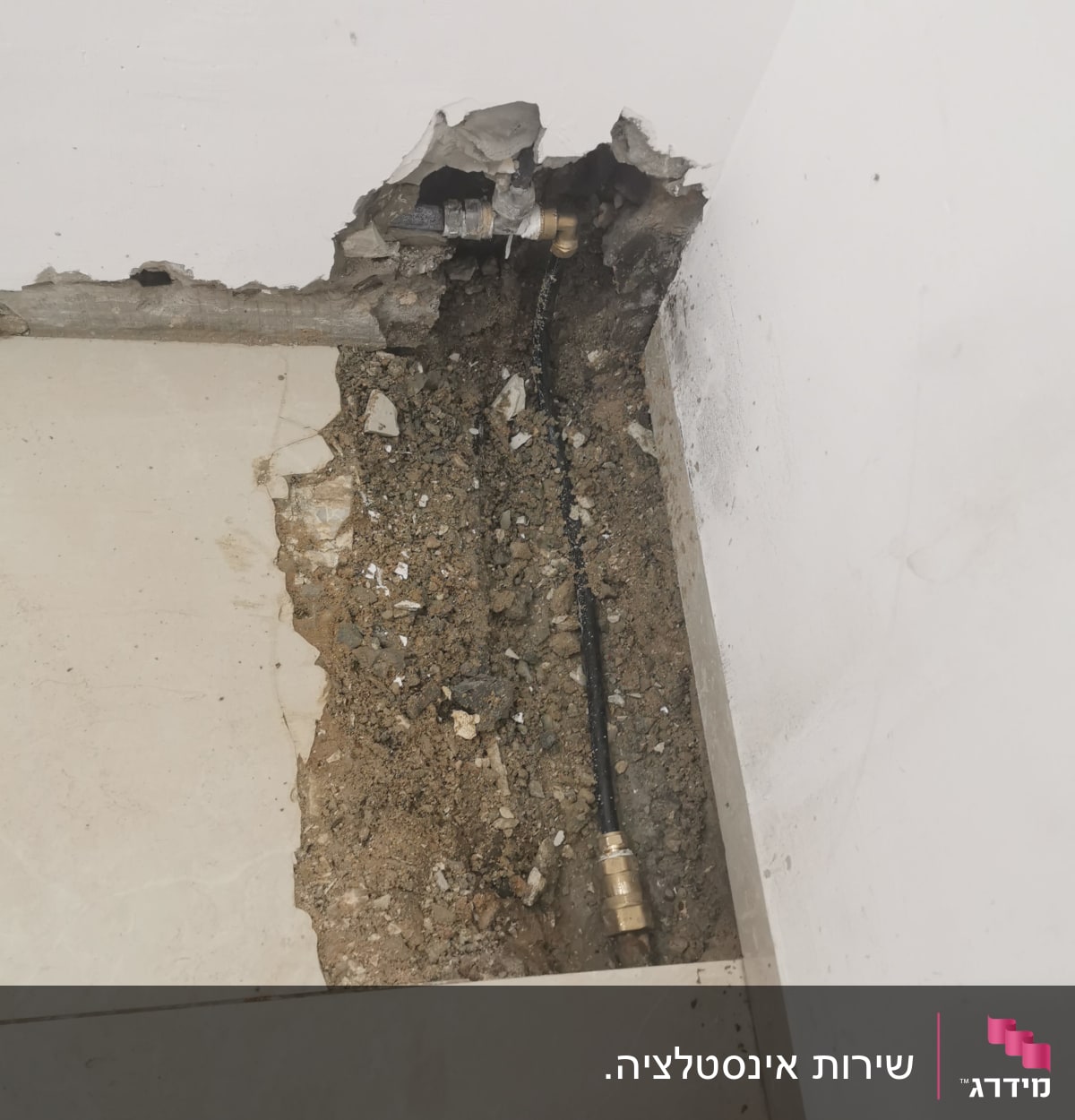 צינור מים חשוף בקיר שבור עם חיבורי מתכת